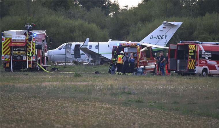 Einsatzkräfte stehen vor einem Kleinjet, der nach der Landung auf dem Flugplatz Egelsbach im Kreis Offenbach hinter dem Maschendrahtzaun in einem Feld liegt. Der Pilot – Frosta-Seniorchef Dirk Ahlers – blieb unverletzt. 