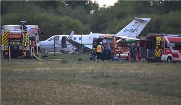 Einsatzkräfte stehen vor einem Kleinjet, der nach der Landung auf dem Flugplatz Egelsbach im Kreis Offenbach hinter dem Maschendrahtzaun in einem Feld liegt. Der Pilot – Frosta-Seniorchef Dirk Ahlers – blieb unverletzt. 