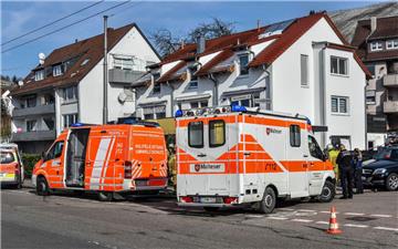 Einsatzkräfte von Rettungsdiensten und Polizei stehen in Esslingen vor dem Haus, in dem mehrere Tote gefunden wurden.