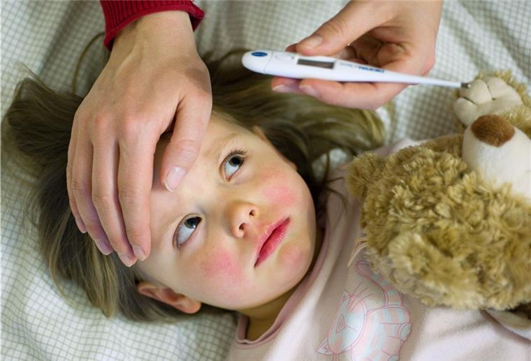 Mehr Kinderkrankengeld für Eltern wegen Corona Ein Mädchen mit Fieber.