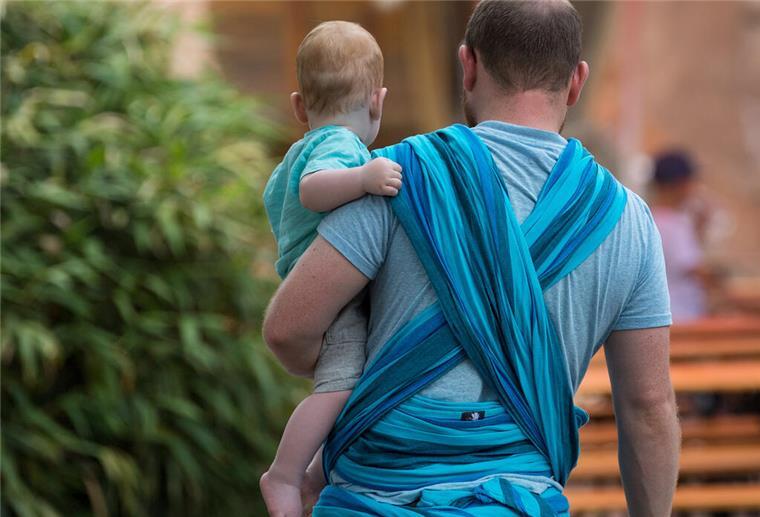 In Bremerhaven beziehen bundesweit die wenigsten Väter Elterngeld Ein Mann hält ein Baby auf dem Arm.