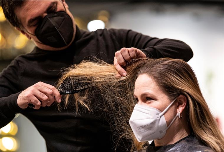 Die Friseure öffnen wieder Shan Rahimkhan, Friseur, begutachtet die Haare der ersten Kundin seines Friseurladens nach der Wiedereröffnung. Nach wochenlanger Schließung öffnen in Berlin die Frisiergeschäfte wieder.