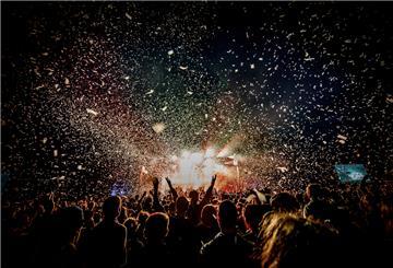 Festivalfans feiern im Konfettiregen.