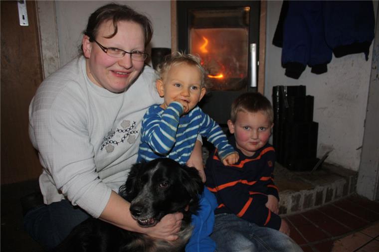 Endlich wieder vereint: Tanja Drechsler mit ihren Söhnen Timo (links) und Christian sowie Familienhund Jasper am warmen Ofen.