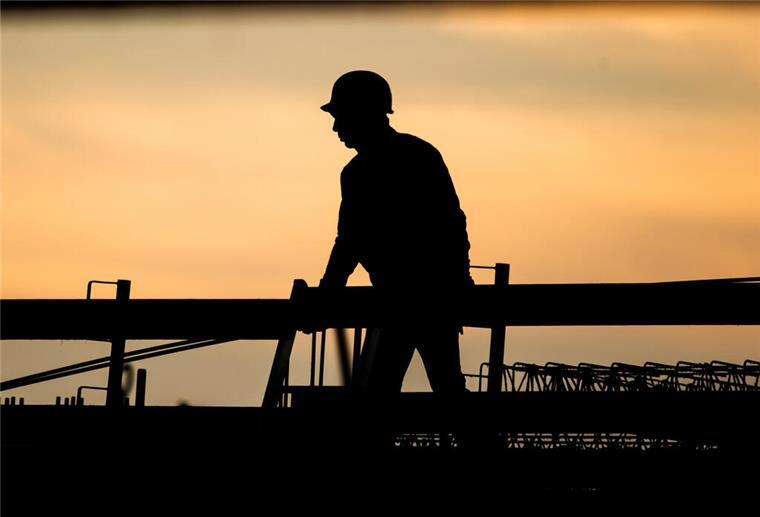 Macht Dein Job Dich wirklich glücklich? Unser Test verrät es Dir Silhouette eines Bauarbeiters vor Sonnenuntergang
