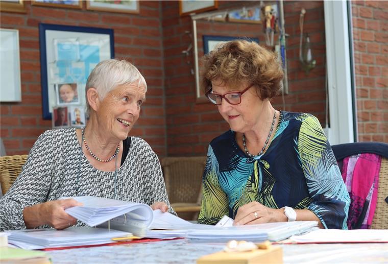 Tarmstedt: Ein Buchprojekt bringt Menschen zusammen Zwei Frauen sitzen vor einem Stapel Papier und sprechen miteinander.