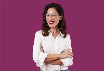Eine Frau mit Brille zwinkert in die Kamera.