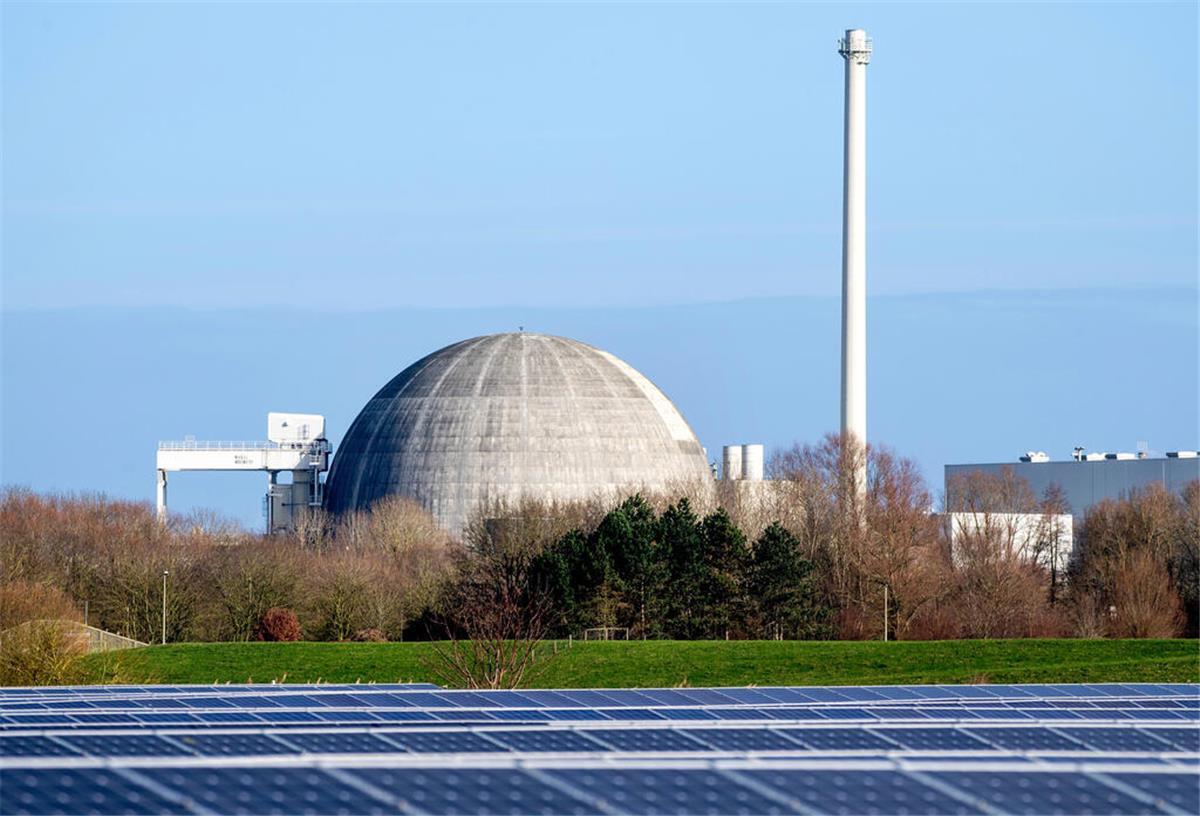 Das bereits stillgelegte und seit 2018 im Rückbau befindliche Kernkraftwerk Unterweser (KKU) steht hinter Photovoltaikanlagen eines Solarparks.