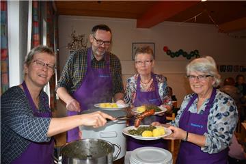 Erst kochen die Ehrenamtlichen das Essen, dann bringen sie es den Gästen an die Tische. Antje Plenter-Böning (von links), Walter Janßen, Birgit Kolschen und Hilke Freese servieren im Gemeindehaus in Seefeld Grünkohl mit Pinkel und Salzkartoffeln.