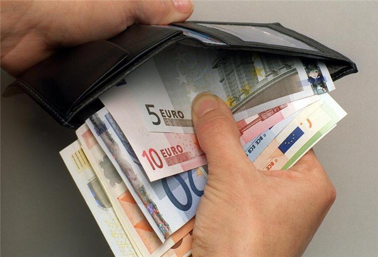 Klimageld gestrichen: Merz-Regierung setzt auf Stromsteuer Eine Person verstaut mehrere Geldscheine in ihrer Brieftasche.