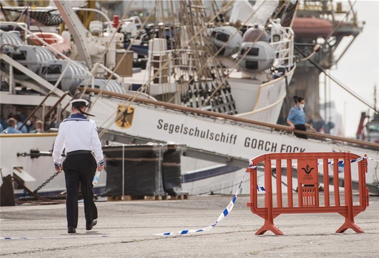 Weitere Ermittlungen wegen Untreue bei Sanierung der „Gorch Fock“ Mann läuft vor dem Segelschulschiff "Gorch Fock" über ein Flatterband.