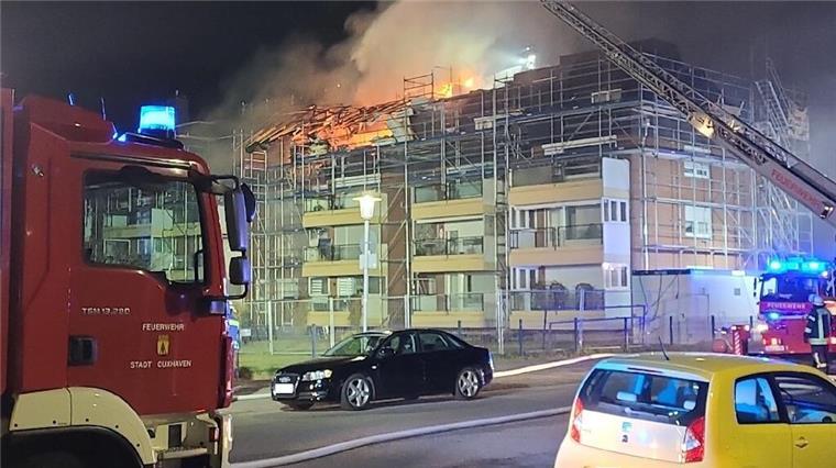 Ein Haus in der Stadt Cuxhaven steht in Flammen. Feuerwehrautos sind auch dort. 