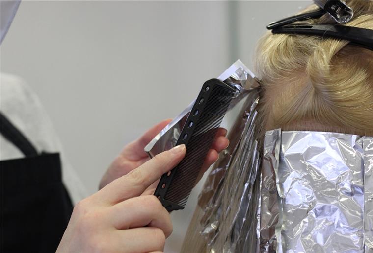 Bedrängt und bedroht: Friseure im Raum Zeven Eine Friseurin arbeitet mit einem Kamm an einem Modellkopf.