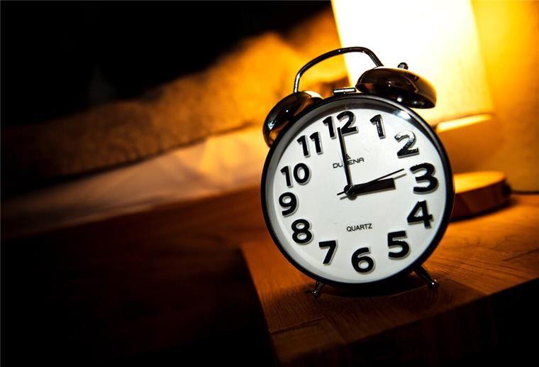 Zeitumstellung 2025: Eine Stunde zurück – das ändert sich im Oktober Eine Uhr steht neben einem Bett.