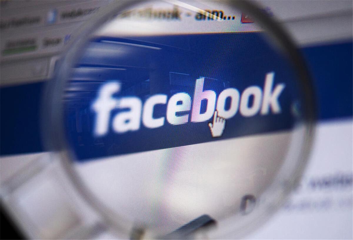Blick durch eine Lupe auf das Logo des sozialen Netzwerkes Facebook, aufgenommen am 04.02.2011 in Berlin