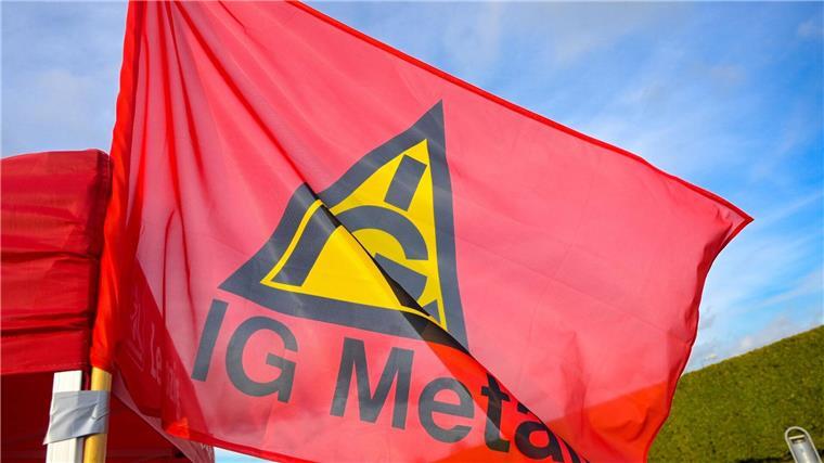 Airbus-Beschäftigte fordern Investitionen in Rüstungsgüter Fahne mit Logo der IG Metall an einem Stand bei einem Streik.