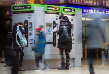 Menschen in der U-Bahn Station Hauptbahnhof kaufen Tickets an einem Fahrkartenautomaten.