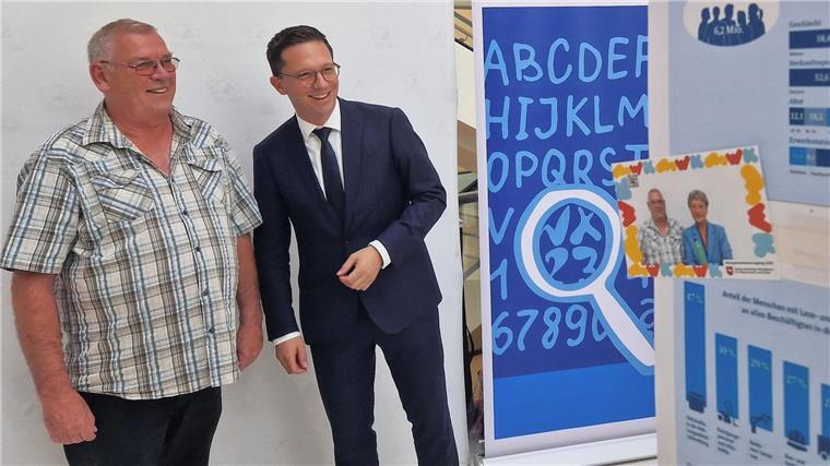 Falko Mohrs (r), Wissenschaftsminister von Niedersachsen, und der Betroffene Uwe Boldt positionieren sich vor einer Fotobox, die anlässlich des bevorstehenden Weltalphabetisierungstages im Landtag aufgestellt wurde.