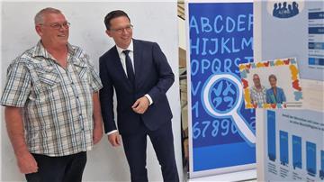 Falko Mohrs (r), Wissenschaftsminister von Niedersachsen, und der Betroffene Uwe Boldt positionieren sich vor einer Fotobox, die anlässlich des bevorstehenden Weltalphabetisierungstages im Landtag aufgestellt wurde.