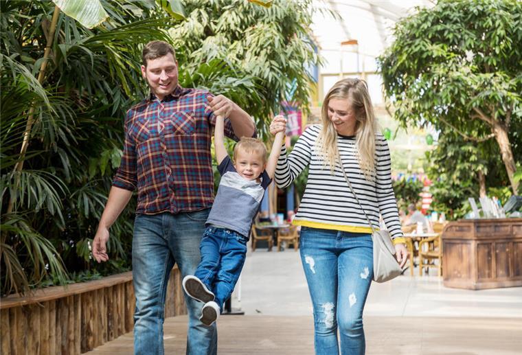 Nach Fast-Pleite: Center Parcs reißt auch in Tossens Steuer rum Ein Mann und eine Frau heben ein Kind in ihrer Mitte hoch.