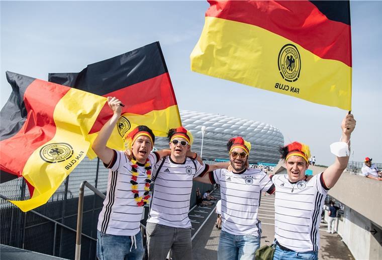 Maskenpflicht ignoriert: Kritik an Fußballfans Fans der deutschen Fußballnationalmannschaft feiern vor dem Stadion in München.