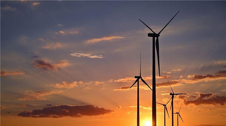 Neue Forschungsanlage soll Windenergie weiterbringen Farbenprächtig leuchtet der Sonnenuntergang über einem Windenergiepark.