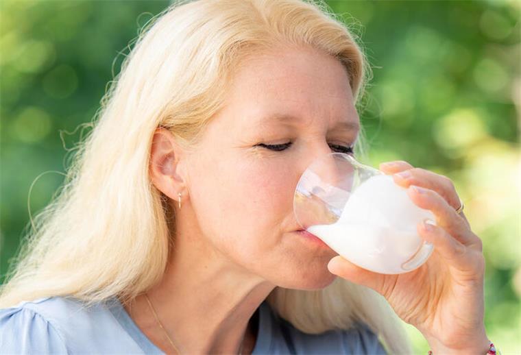 Probiotika für eine intakte Darmflora Eine Frau trinkt ein Glas fermentierter Milchprodukte.