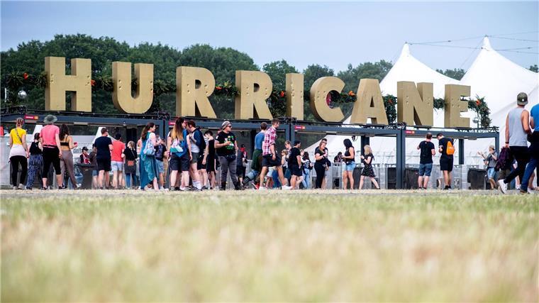 Festivalbesucher gehen 2022 am Haupteingang des Hurricane Festivals entlang.