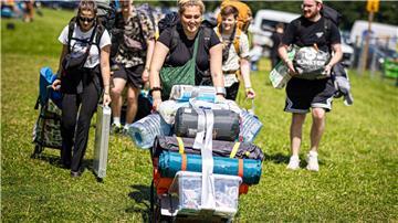 Festivalbesucher kommen mit ihrem Gepäck am Zeltplatz an.