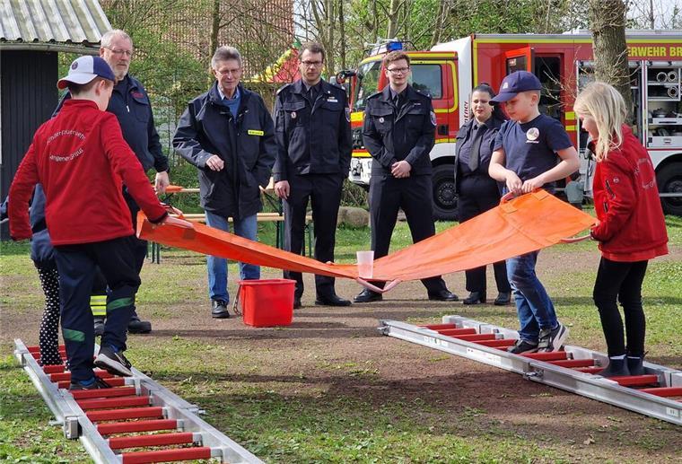 Kinderflamme: Leistungsabzeichen mit jeder Menge Teamgeist Feuerwehrdezernent Stadtrat Peter Skusa schaut sich zusammen mit dem Jugendfeuerwehrwart Jan Haucke und den Organisatoren Nathalie Zander und Thies Renken gespannt eine Station der Kinderflamme an.