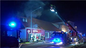 Feuerwehrleute löschen aus dem Korb einer Drehleiter heraus den Brand in einem Restaurant in Syke.