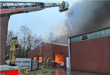 Feuerwehrleute löschen einen Brand in einer Halle eines Reifenlagers in einem Gewerbegebiet.