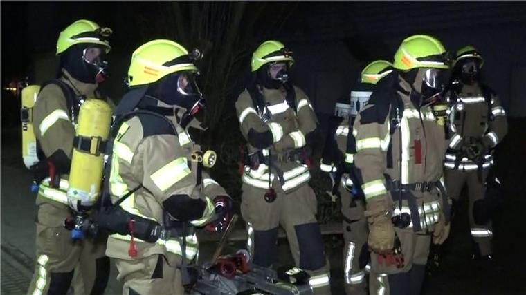 Brand in Ronnenberg verursacht halbe Million Euro Schaden Feuerwehrleute mit Atemschutzmasken stehen vor dem Mehrfamilienhaus in Ronnenberg.