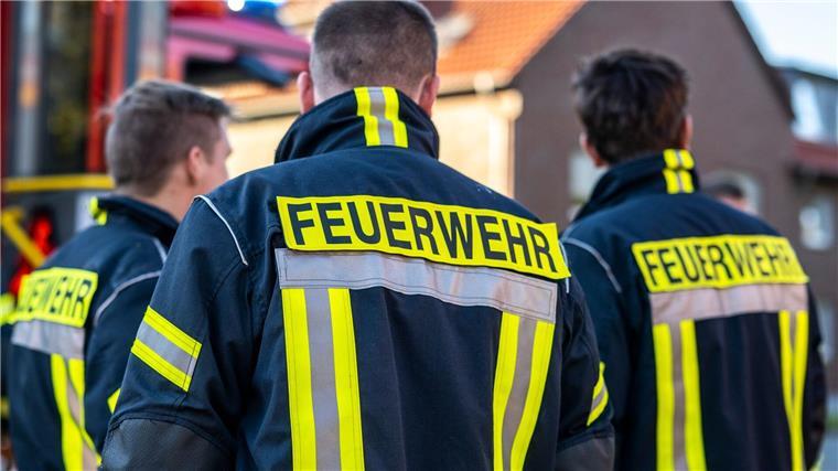 Einsatzkräfte bauen mobile Deiche in Oldenburg ab Feuerwehrleute stehen zusammen, um den Einsatz zu besprechen.