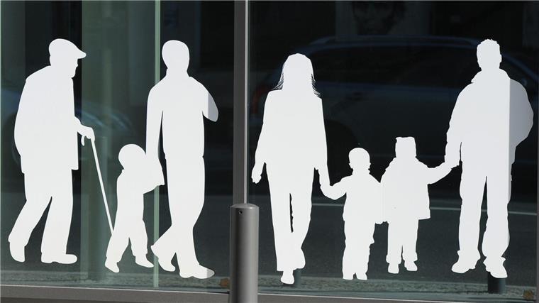 Rückblick im Statistikamt: Weniger Geburten, mehr Hochzeiten Figuren von Menschen in verschiedenem Alter sind auf Fensterscheiben aufgeklebt.