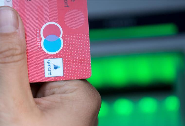 Ein Hand hält eine EC-Karte in der Hand