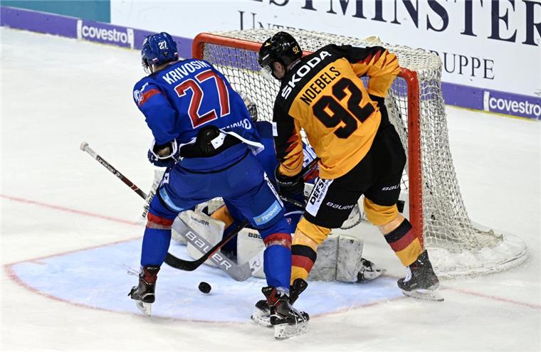 Eishockey: DEB-Team verliert gegen die Slowakei Filip Krivosik (links) aus der Slowakei und Marcel Noebels (Deutschland) kämpfen vor dem deutschen Tor um den Puck.