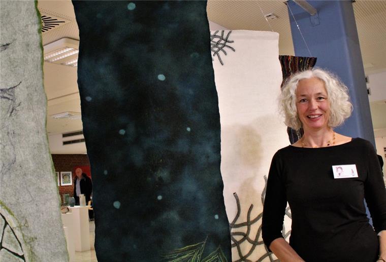 Beverstedt: Jubiläumsausstellung zeigt Vielfalt der Arche Eine Frau mit grauen Haaren steht vor einem Kunstwerk aus Filz.