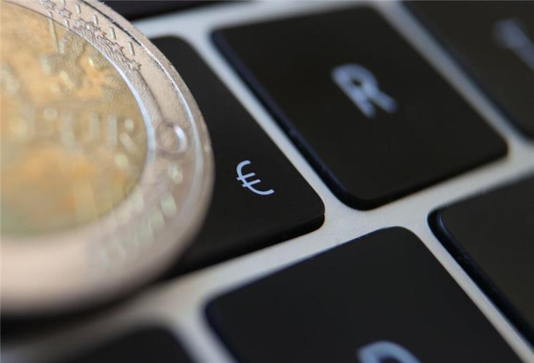 Finfluencer: Wenn Finanztipps auf TikTok ins Geld gehen können Ein Zwei Euro Geldstück liegt auf einer Tastatur.