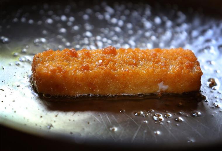ILLUSTRATION - Ein Fischstäbchen wird in einer Pfanne gebraten. (Zu dpa "Fischstäbchen sollen teurer werden") (zu dpa: «Möglicherweise Kunststoff in Fischstäbchen – Rückruf»)