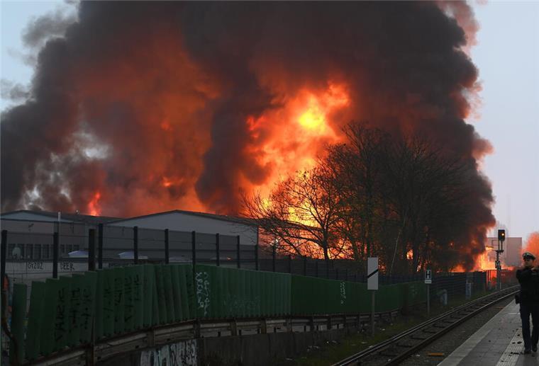 Flammen steigen auf bei einem Großbrand in Hamburg-Rothenburgsort. Aufgrund starker Rauch- und Gasentwicklung, mit möglicher chemischer Bestandteile, hat die örtliche Polizei eine amtliche Gefahrenmeldung herausgegeben.