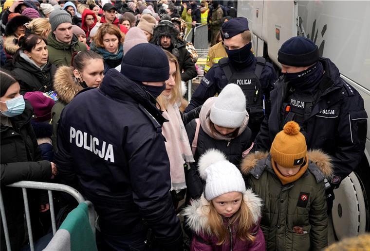 Ukraine: Hunderttausende Menschen in Gefahr Flüchtlinge, die vor dem Krieg in der Ukraine geflohen sind, drängen sich, um in einen Bus zu steigen und den Grenzübergang Korczowa in Polen zu verlassen.