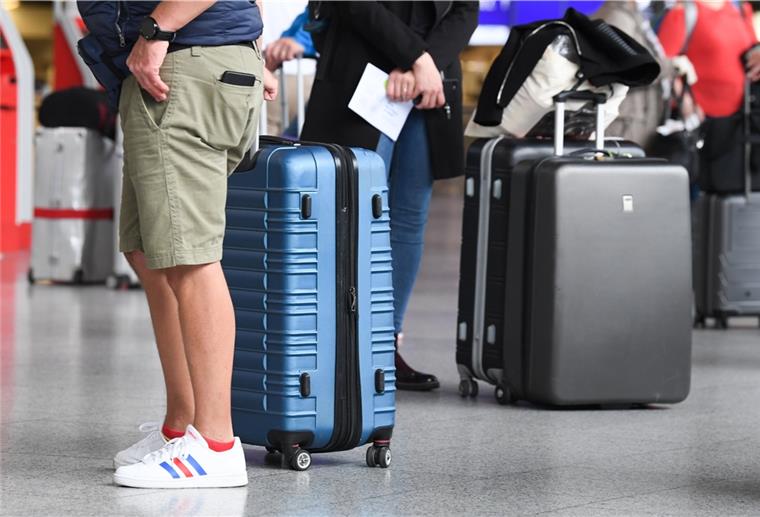 Flugreisende stehen im Flughafens am Check-in-Schalter an. Reiserückkehrer aus Risikogebieten sollen sich an Flughäfen verpflichtend auf das Coronavirus testen lassen.