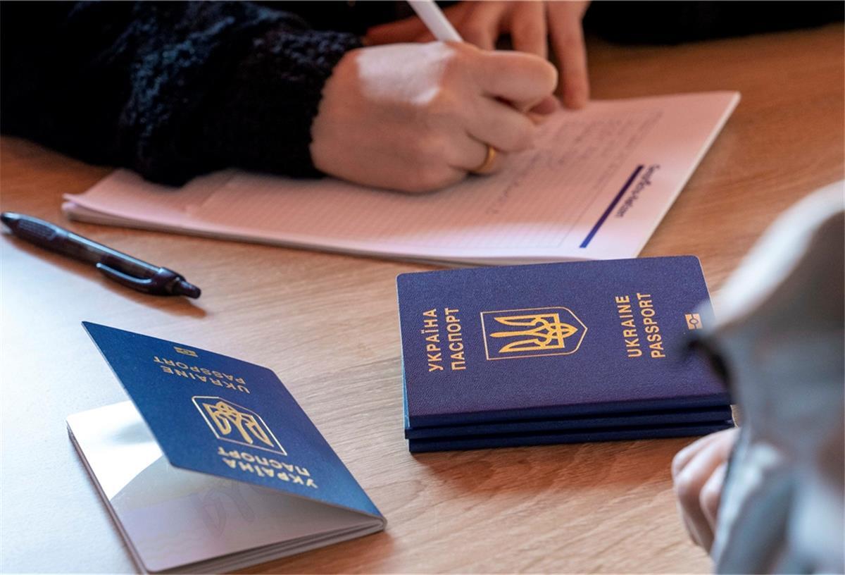 Ukrainische Flüchtlinge in Bremerhaven: Was Helfer wissen müssen (Liste Stand 9. März) Fotos ukrainische Pässe im Vordergrund. Der russische Angriff auf die Ukraine stellte das Leben fuer Millionen Menschen auf den Kopf. Immer mehr ukrainische Fluechtlinge verlassen ihr Land.