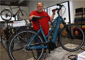 Frank Langner steht einem Fahrrad in seinem Geschäft
