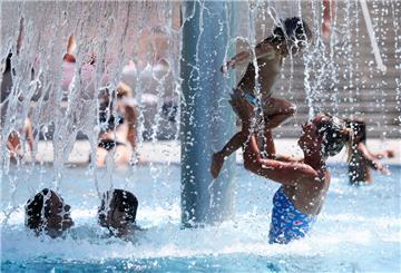 Frauen und Kinder spielen unter einem Wasserpilz im Freibad. Auch in den drei Bädern in der Samtgemeinde Tarmstedt dürften sich in diesem Jahr viele Familien tummeln. Windparkbetreiber wpd sponsert 400 Familien-Jahreskarten. Die Verlosung beginnt jetzt.