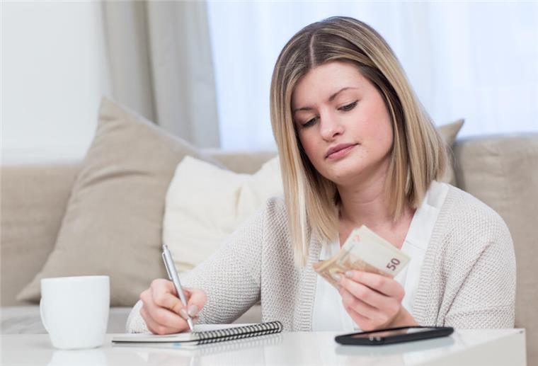 Weniger Rente, mehr Risiko: Warum Frauen früh vorsorgen sollten Eine Frau mit Geld in der Hand
