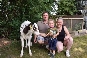 Frederik mit seinen Eltern Stephan und Jessica und mit Kälbchen Celina.