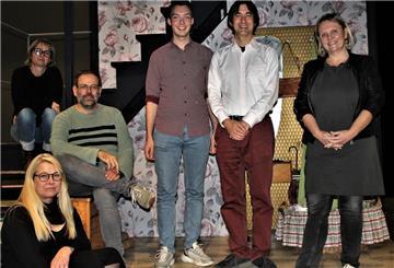 Mitarbeiter des Stadttheaters Bremerhaven stehen auf einer Theaterbühne und posieren für ein Foto.