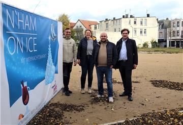 Zwei Männer und zwei Frauen stehen neben einem Plakat mit der Aufschrift Nordenham on Ice.